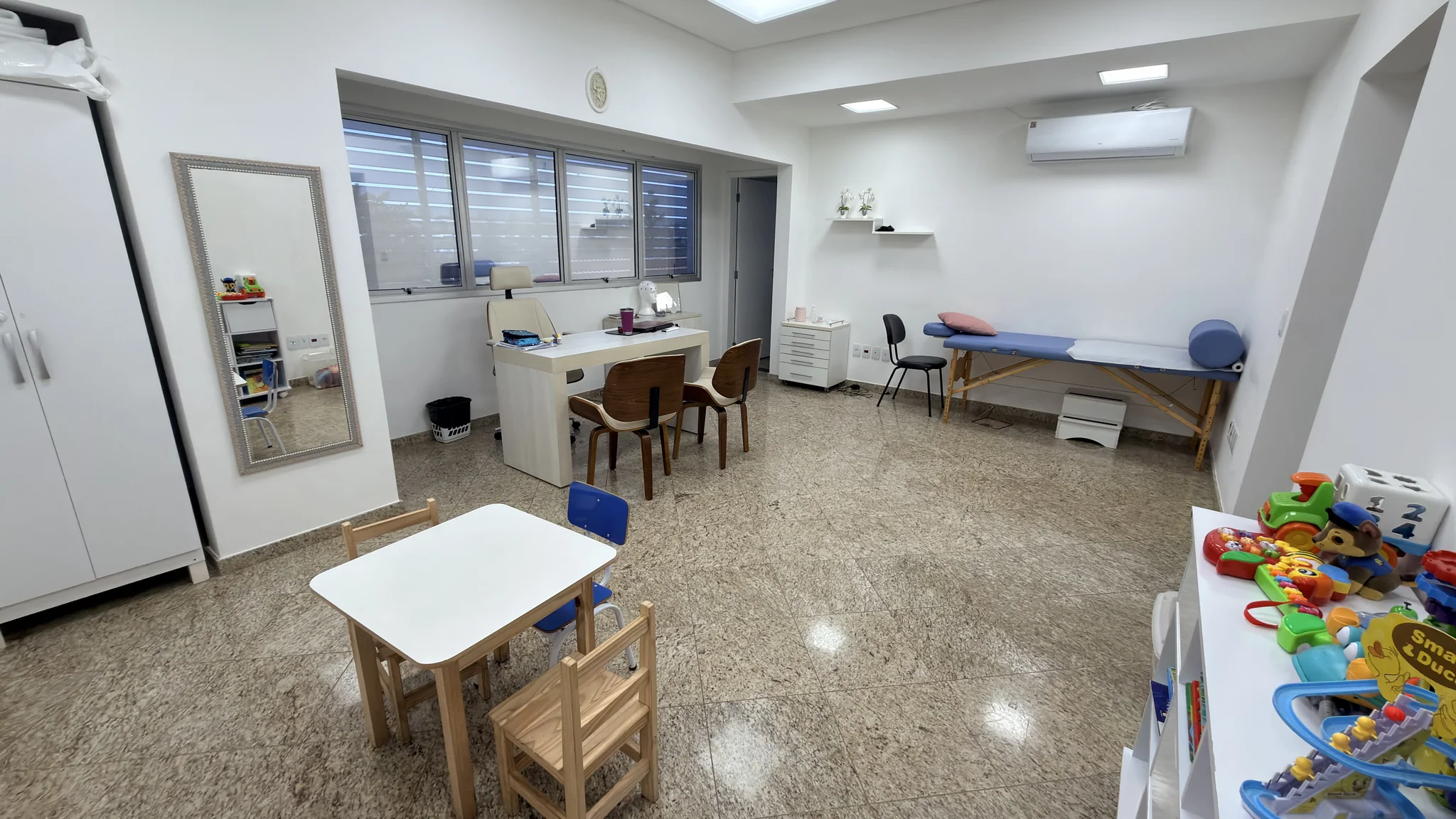 Consultório multidisciplinar com estante de brinquedos e jogos pedagógicos